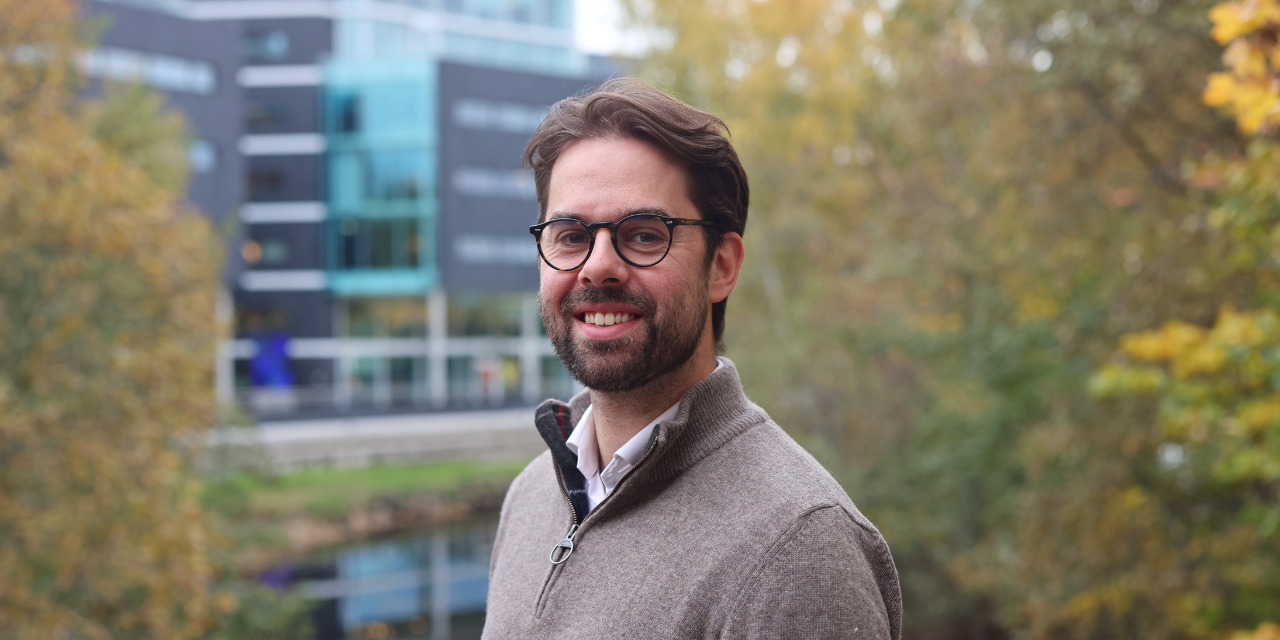 Man smiling with office buildings in the background